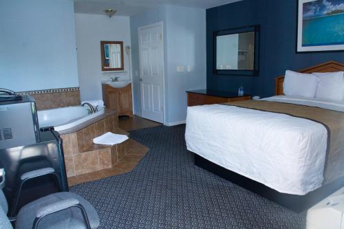 Howell9点汽车旅馆的酒店客房配有一张床和浴缸。