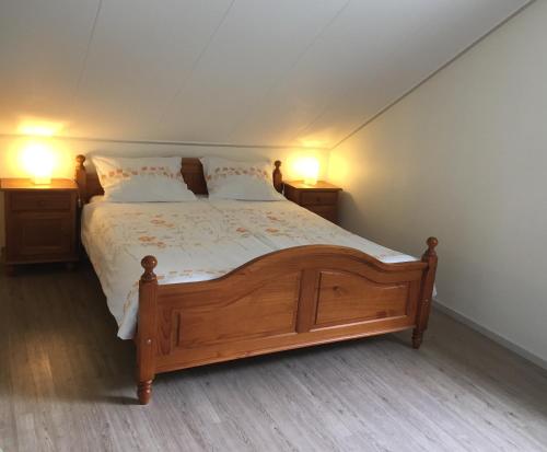 东卡佩勒de Duinroos的一间卧室配有一张带两盏灯的大木床。