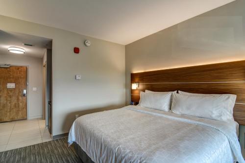 沃尔顿堡滩Holiday Inn Express - Fort Walton Beach Central, an IHG Hotel的酒店客房,配有一张带木制床头板的床