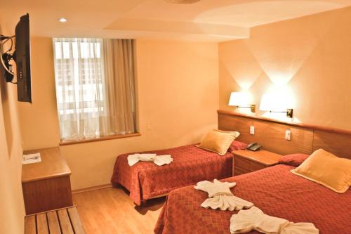 科尔多瓦菲利普二世酒店的酒店客房,配有两张带毛巾的床