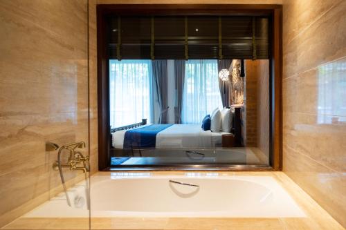 清迈Phor Liang Meun Terracotta Arts的带浴缸的浴室和卧室