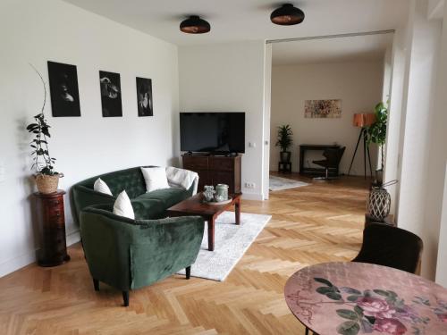 柏林exklusives Studioapartment - in traumhafter Lage direkt am Halensee的客厅配有绿色沙发和桌子
