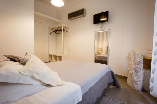 斯培西亚Affittacamere e appartamenti - Rent rooms and Apartments Le Camere Nel Corso - ADULTS ONLY的卧室配有白色的床和椅子