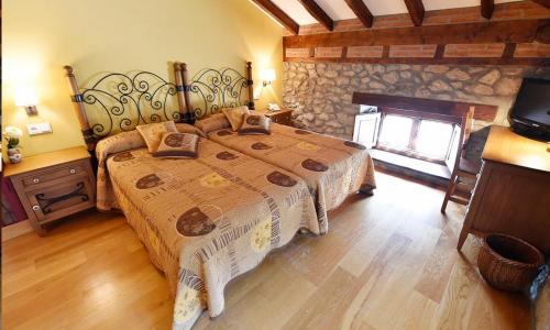 霍兹纳约特米诺旅馆的一间卧室设有一张带石墙的大床