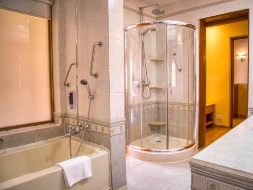 坎多林Acron Candolim Regina的带淋浴、浴缸和盥洗盆的浴室