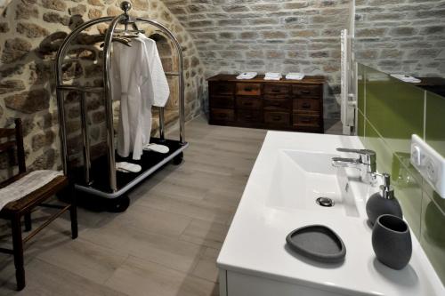 SanilhacChambre Comballe charmante avec jacuzzi的浴室配有白色水槽和石墙