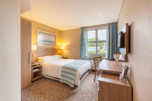 伊丽莎白港Town Lodge Gqeberha的配有一张床、一张书桌和一扇窗户的酒店客房