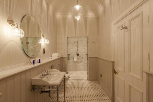 基拉尼凯赫尔梅恩酒店的白色的浴室设有水槽和淋浴。