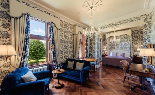 基拉尼凯赫尔梅恩酒店的一间卧室配有一张床和一张蓝色的沙发