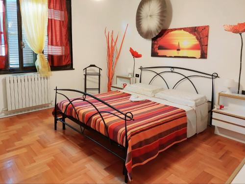 圣温琴佐Villa happy days的一间卧室配有一张带红色和橙色毯子的床