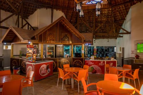 IguaraçuOdy Park Resort Hotel的一间在房间内配有桌椅的餐厅