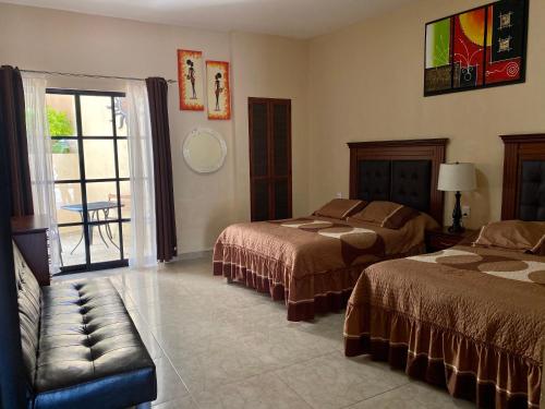 贝纳尔Hotel Villa Bernal的酒店客房设有两张床和窗户。