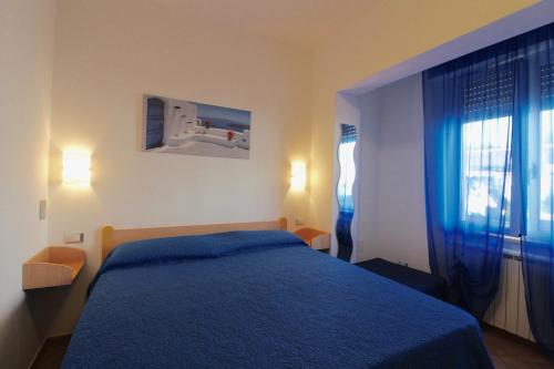 圣温琴佐La Rosa dei Venti的一间卧室设有蓝色的床和窗户。