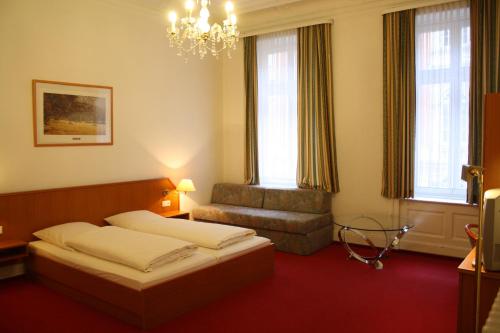 汉堡阿拉米达酒店的一间卧室配有一张床、一把椅子和一个吊灯。