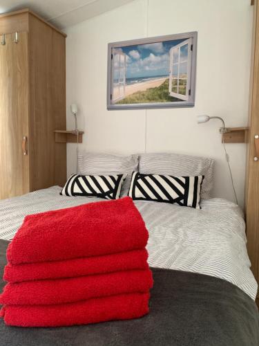 卡兰茨奥赫Casa Callantsoog的卧室配有红色毯子,位于床上