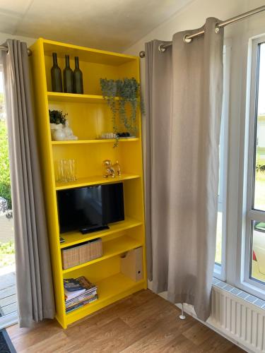 卡兰茨奥赫Casa Callantsoog的电视房里的黄色书架