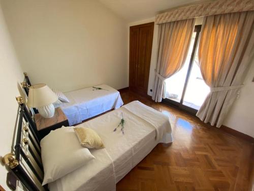 Olías del ReyVILLA BLANCA的一间卧室设有两张床和大窗户