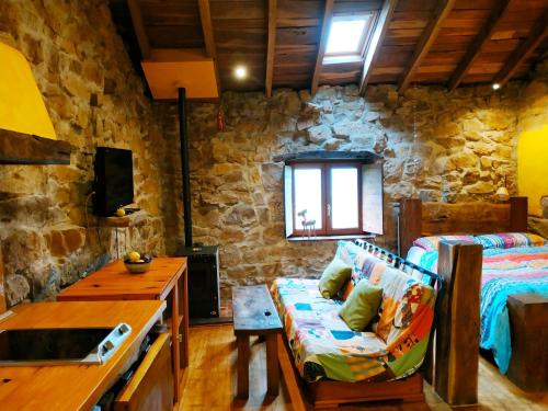 La CavadaApartamento en Plena Naturaleza的带沙发和石墙的客厅