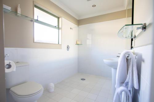 默奇森默奇森汽车旅馆的白色的浴室设有卫生间和水槽。