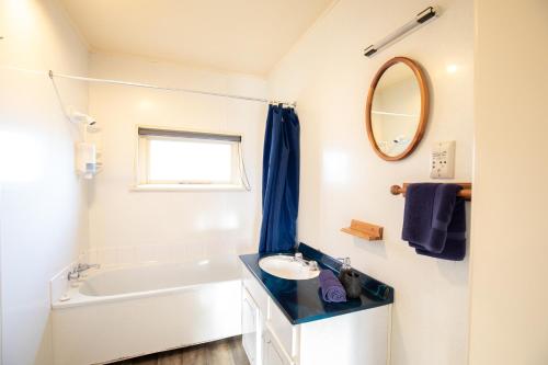 蒂阿瑙高山景观汽车旅馆的一间带水槽、浴缸和镜子的浴室