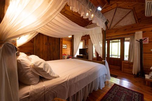 罗什平纳偌诗佩内特诺伊酒店的一间卧室配有一张带白色床单和窗帘的床