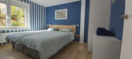 德哈恩Seagarden by Valdemosa的蓝色的卧室设有床和窗户