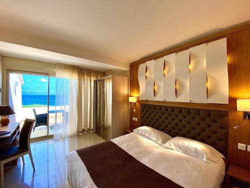 圣弗洛朗特多拉酒店的一间卧室配有一张床、一张书桌和一个窗户。
