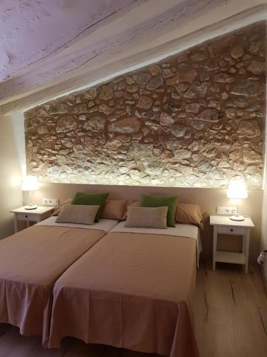 普拉特迪普Cal Moreno的一间卧室设有两张床和石墙