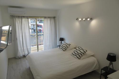 戛纳Luxe 6 couchages proxi bord de mer centre ville的卧室配有白色的床和两个枕头