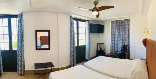 隆达唐米格尔酒店的一间卧室设有两张床和两个窗户。