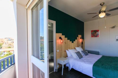 卡布勒通Hôtel La Baïne的一间卧室配有一张绿色墙床