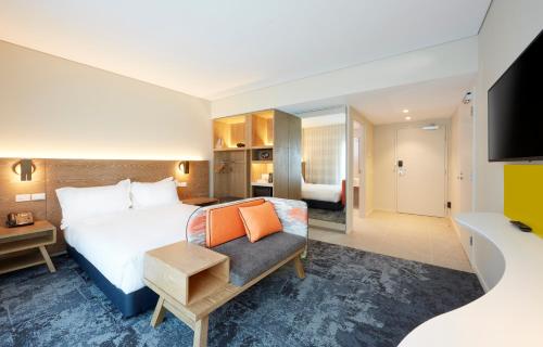 阿德莱德阿德莱德市中心智选假日酒店的一间酒店客房,配有一张床和一台电视