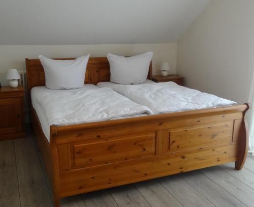 多瑙艾辛根Ferienwohnung Schwarzwald-Baar Blick的一张带两个白色枕头的木床