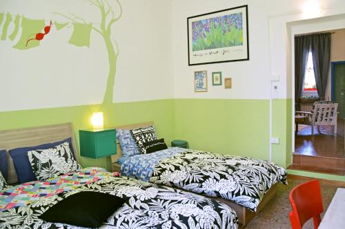 博洛尼亚Ottavo Portone的卧室配有两张床,墙上有一棵树