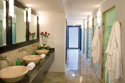 马萨特兰Luxury Suites By Estrella del Mar的一间带两个盥洗盆和走廊的浴室