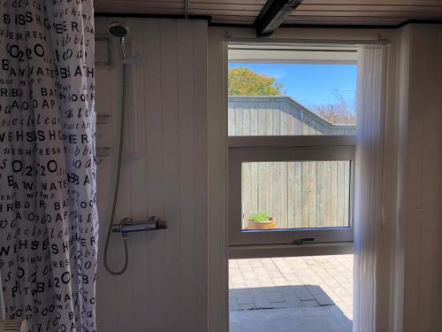 斯卡恩Hyggelig ferielejlighed的浴室设有窗户和浴帘