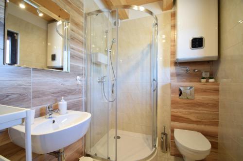 格里兹鲍Domki Letniskowe Marina的带淋浴、盥洗盆和卫生间的浴室
