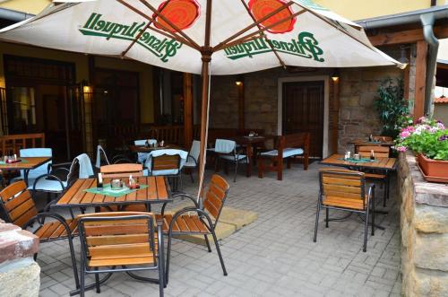 比尔森瓦利斯膳食旅馆的一个带桌椅和遮阳伞的庭院