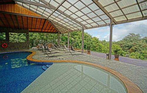 蒙泰韦尔德哥斯达黎加厄尔爱斯达梦泰恩酒店的一个带椅子和凉亭的室外游泳池