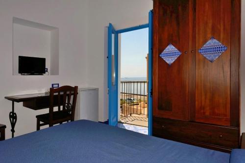 圣马里纳萨利纳坎纳塔酒店的一间卧室设有一扇门,可通往带书桌的阳台