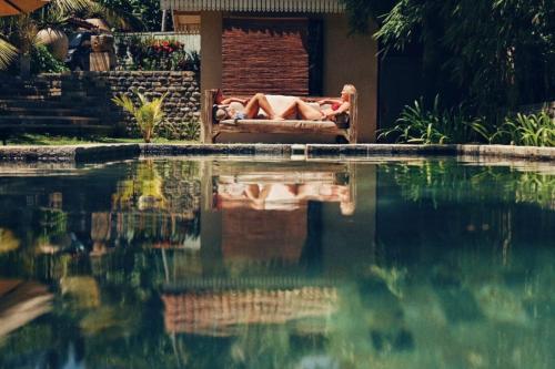坦加拉阿迦瑟夫风景度假屋的躺在游泳池旁沙发上的人