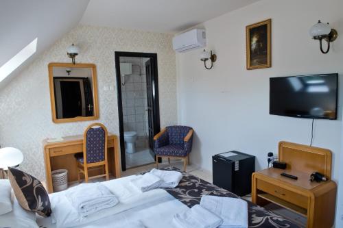 托考伊托尔迪坲加多旅馆的一间卧室配有一张床、两把椅子和电视
