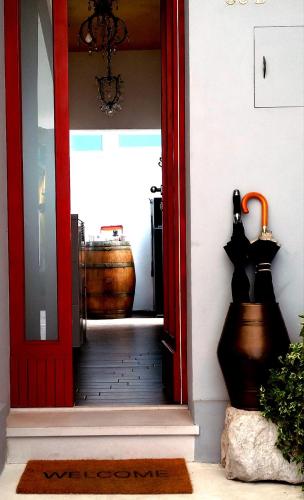 切塞纳蒂科Guest House CorteMazzini36的一道红色的门,通向一个有桶的房间