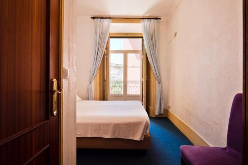 里斯本格里斯住宅酒店的一间小卧室,配有床和窗户