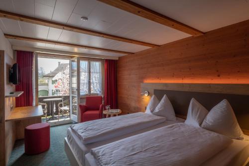 因特拉肯瑞士小屋酒店的酒店客房设有一张床和一个阳台。