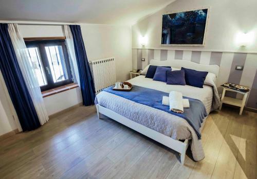 塔尔奎尼亚B&B Antiche Mura的一间卧室配有一张带蓝色枕头的大床