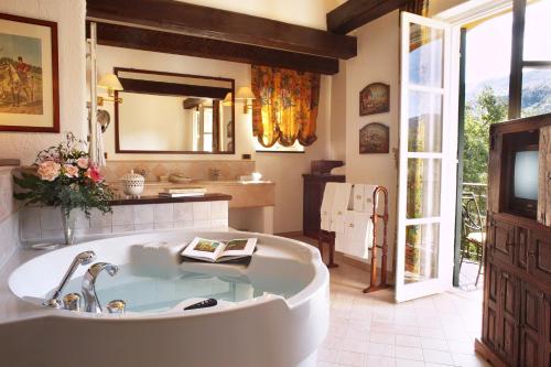 加尔伦达La Meridiana Hotel & Golf Resort的带浴缸和盥洗盆的大浴室