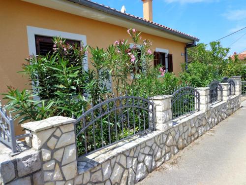 马林斯卡Villa AnaAngela的房屋前有植物的石墙