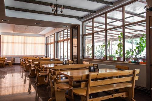 斯塔多伊兰Villa Marija - Izgrev的餐厅设有木桌、长凳和窗户。