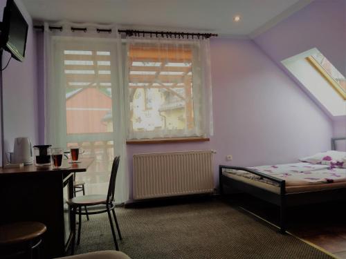 斯托尼拉斯奇Na Skwerku的一间卧室配有一张床、一张桌子和一个窗户。
